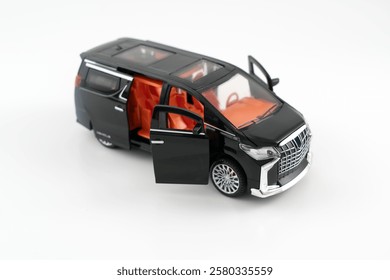 Side view of  a miniature of a black Multi-Purpose Vehicle (MPV) car on white background