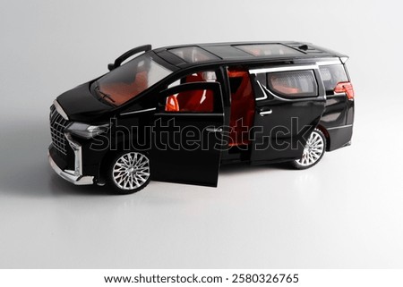 Side view of  a miniature of a black Multi-Purpose Vehicle (MPV) car on white background