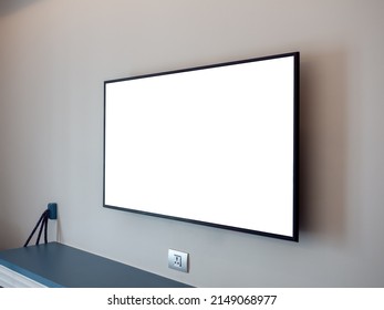 Side View Of Mockup White Blank Space On TV Screen On The Wall Near The Plug And Empty Shelf In The Hotel Bedroom.