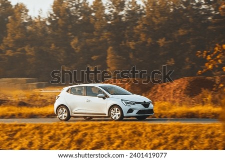 Side view of modern hatchback moving on the highway.