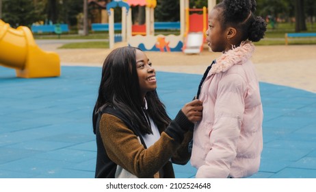 Side View Mom Laugh With Daughter In Playground Cute Little Girl Tell Funny Story Mother Smiling Listening To Kid Child Emotionally Talking Outdoors Family Happily Spend Time After School Caring Mommy