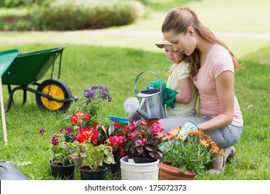 Side View Of A Mother And Daughter Engaged In Gardening