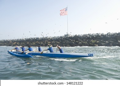 Side view of multiethnic outrigger canoeing team heading to race stage