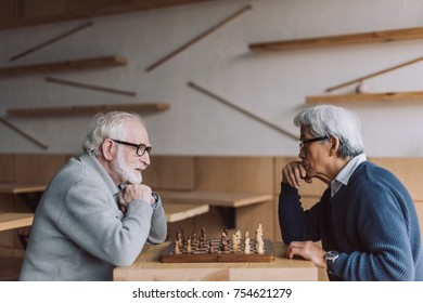 Side View Of Multiethnic Senior Men Playing Chess