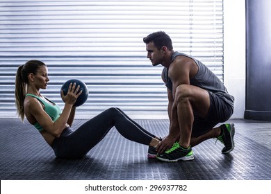 Side view of a muscular couple doing abdominal ball exercise