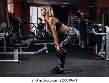 Side View Of Muscular Young Fitness Woman Doing Heavy Deadlift Exercise In Gym