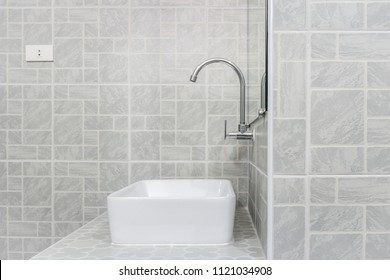 Side View Of New Modern Grey Restroom. It Consists Of Mirror, Ceramic Wash Basin, Countertop And Curve Faucet.