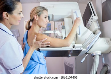 Side view of a nurse preparing a patient for a mammogram at x-ray machine in the hospital