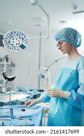 Side View Of Nurse Taking Laparoscopic Instrument From Tray