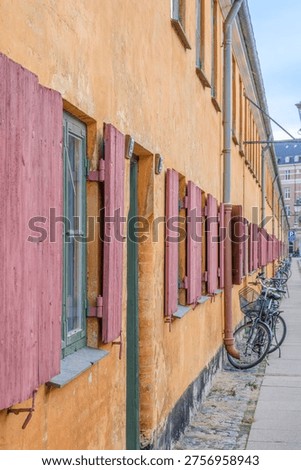 Side View of Nyboder Historic Naval Barracks, Row of Yellow Houses with Red Shutters, Bicycles Parked, Copenhagen