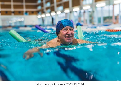 Side view of older adult man swimming with a pool noodle . High quality photo - Powered by Shutterstock