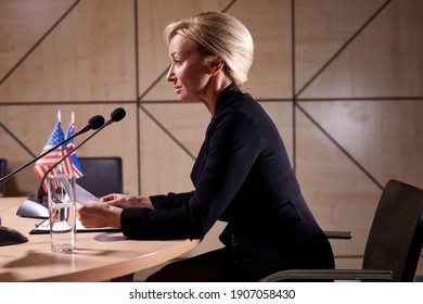 Side View On 50-55 Years Old Executive Woman At Press Conference , Political Leader Woman Speaking Into The Microphone In Boardroom.