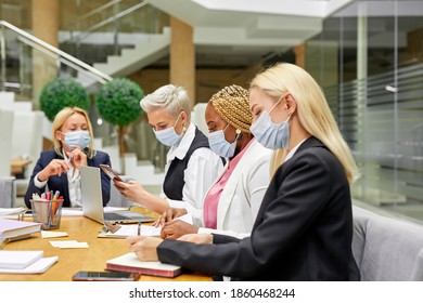 Side View On Busy Colleagues In Masks In The Office, Wearing Formal Clothes, During Pandemic Covid-19