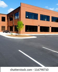 Side View On The Generic Red Brick Office Building With Parking Lot