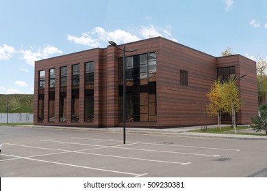 Side View On The Generic Red Brick Office Building With Parking Lot