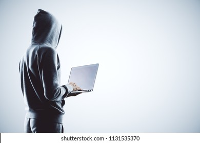 side view on hacker in grey hoody with laptop at white background.