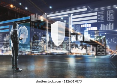 side view on hacker in process with laptop and big digital screen with cyberspace illustration in night city.