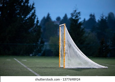 Side View On A Lacrosse Goal On A Turf Field During A Rainy Night Game, With Space For Text