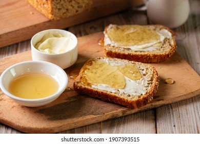 Side view on whole grain bread slices spred with butter and honey - Shutterstock ID 1907393515