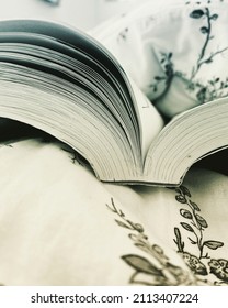 Side view of an open book on bed
