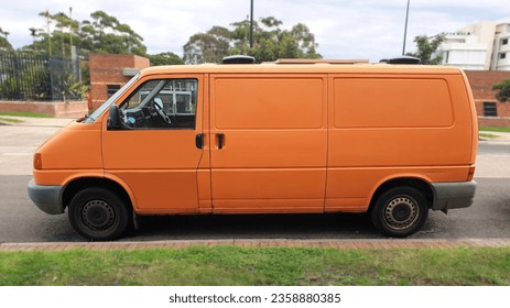 side view of orange Volkswagen van parked on street - Powered by Shutterstock