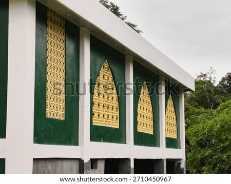 Side view of the outer wall of the Hidayatullah Mosque, Sampir Village, Serang Regency, Banten Province, Indonesia, which is in the process of being painted (green and gold paint)
