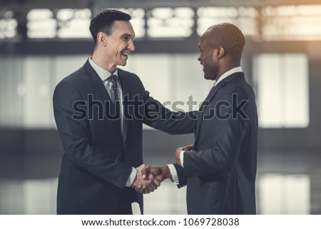 Side view outgoing worker telling with partner while greeting with him. Glad colleagues during communication concept