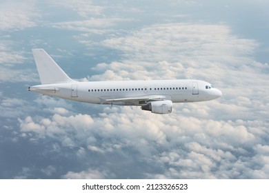 Side View Of A Passenger Jet Liner Flying In The Clouds