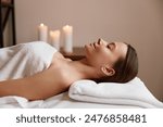 Side view of peaceful woman relaxing in spa salon after massage
