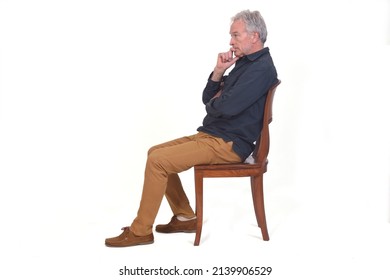 side view of a pensive man sitting on a chair on white background - Powered by Shutterstock