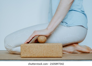 Side view of person doing palmar fascia release with a small cork ball on a cork block. Concept: self care practices at home, SMFR
