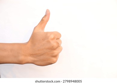 Side view of a person's hand making a thumbs-up gesture against a clean white backdrop, symbolizing success, approval, agreement, or liking something.