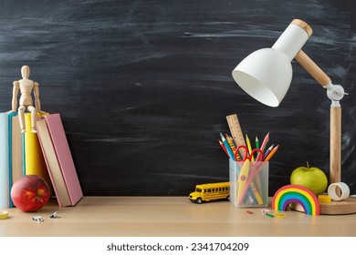 Side view photo of inspirational school setup with desk essentials, pencils, ruler, books, mannequin and more, set against blackboard backdrop. Perfect for educational promotion or motivating messages - Powered by Shutterstock