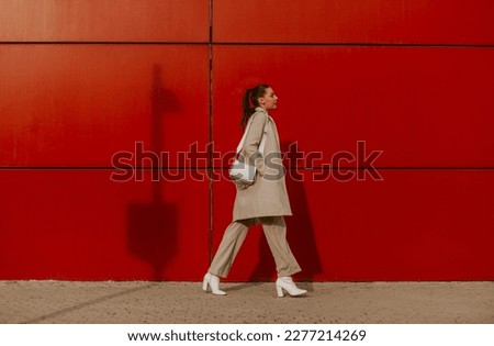 Similar – Image, Stock Photo Woman with a red coat behind a white column, heavily overexposed.