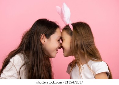 Side View Photo Of Mother And Little Daughter Wearing Bunny Ears On Head Touching Their Noses And Laughing On Easter Holiday. High Quality Photo