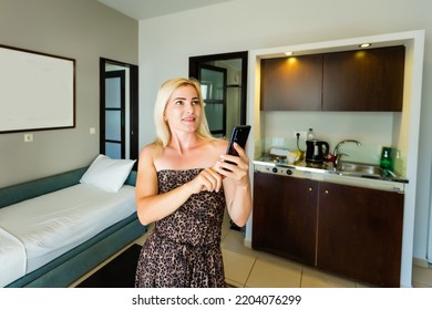 Side View Pleasant Young Woman Using Smart Home System Or Activating Modern Alarm System Before Leaving Apartment. Happy Lady Turning Off Easy Security Technology, When Returning House Or Flat