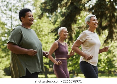 Side view portrait of active senior women running outdoors in park and enjoying sports - Powered by Shutterstock