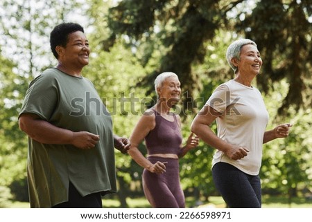 Side view portrait of active senior women running outdoors in park and enjoying sports