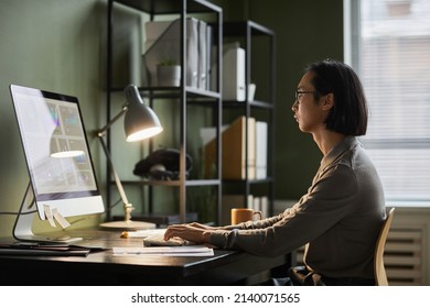 Side View Portrait Of Asian Software Designer Using Computer While Working Late At Home Office, Copy Space