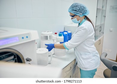 Side View Portrait Of Beautiful Nurse Cleaning In The Workplace And Disinfection All Dentist Room