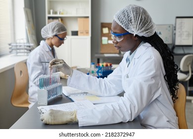 Side View Portrait Of Black Female Scientist Doing Experiments With Test Tubes In Medical Laboratory