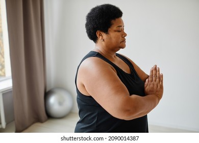 Side View Portrait Of Black Senior Woman Meditating With Eyes Closed While Doing Yoga Indoors, Copy Space