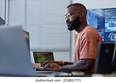 Side View Portrait Of Black Software Developer Using Computer In High Technology Office, Data Systems And Programming