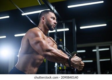 Side View Portrait Of A Bodybuilder Working On His Chest Muscles With Cable Crossover In A Gym