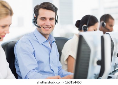 Side view portrait of business colleagues with headsets using computers at office - Powered by Shutterstock