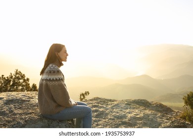 Side view portrait of a casual woman in the top of a cliff contemplating views in winter