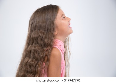 Side View Portrait Of A Cheerful Littile Girl Isolated On A White Background