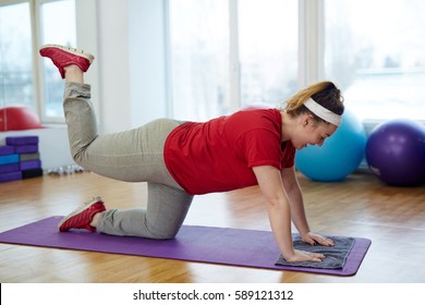 Side View Portrait Of Determined Overweight Woman Working Out In Fitness Studio:  Doing Back Kicks On Yoga Mat