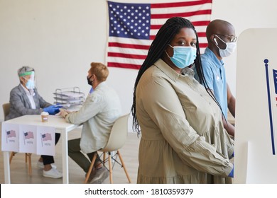 Side View Portrait Of Female African-American Voter Standing In Booth And Looking At Camera On Post-pandemic Election Day, Copy Space