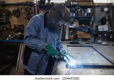 Side view portrait of female welder working with metal in industrial workshop, copy space - Powered by Shutterstock